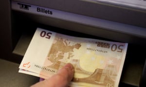 Un turista británico retira billetes del euro un cajero automático