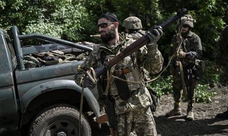 Ukrainian servicemen get ready to move toward the frontline at a checkpoint near Lysychansk in the eastern Ukrainian region of Donba