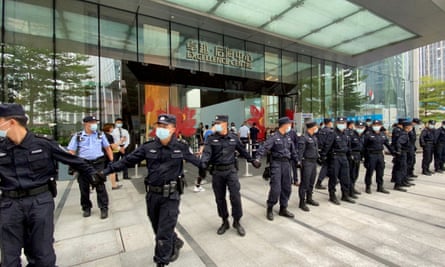 Security personnel form a human chain as they guard outside the Evergrande’s headquarters, in Shenzhen, as people gathered to demand repayment of loans in 2021.