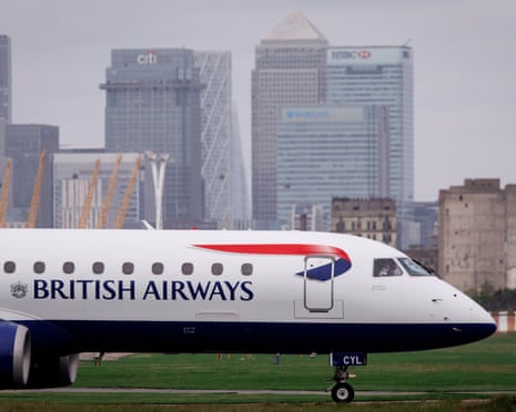 A British Airways plane taxis before take-off from London City Airport, with the Canary Wharf financial district in the background, in east London in April.
