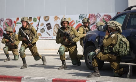 Israeli soldiers deploy in an area where civilians were killed in Sderot on 7 October.