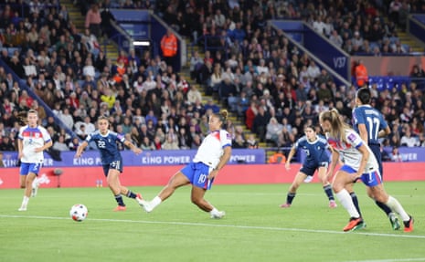 Lauren James kicks the ball to score, as an opposing player chases behind her