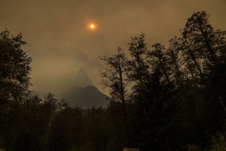 Smoke obscures a mountain peak and the sun.