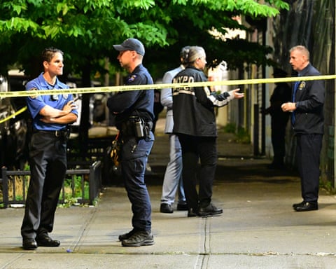 police officers stand near yellow crime scene tape