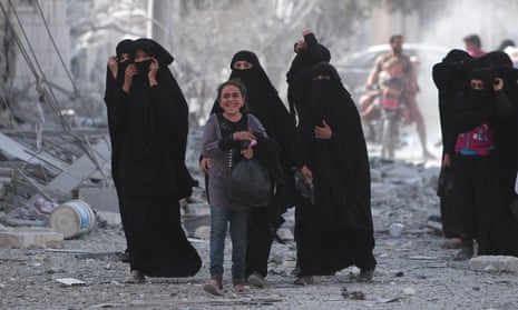 A girl walks with women who were evacuated by Syrian Democratic Forces fighters from the Isis-controlled city of Manbij, Syria.
