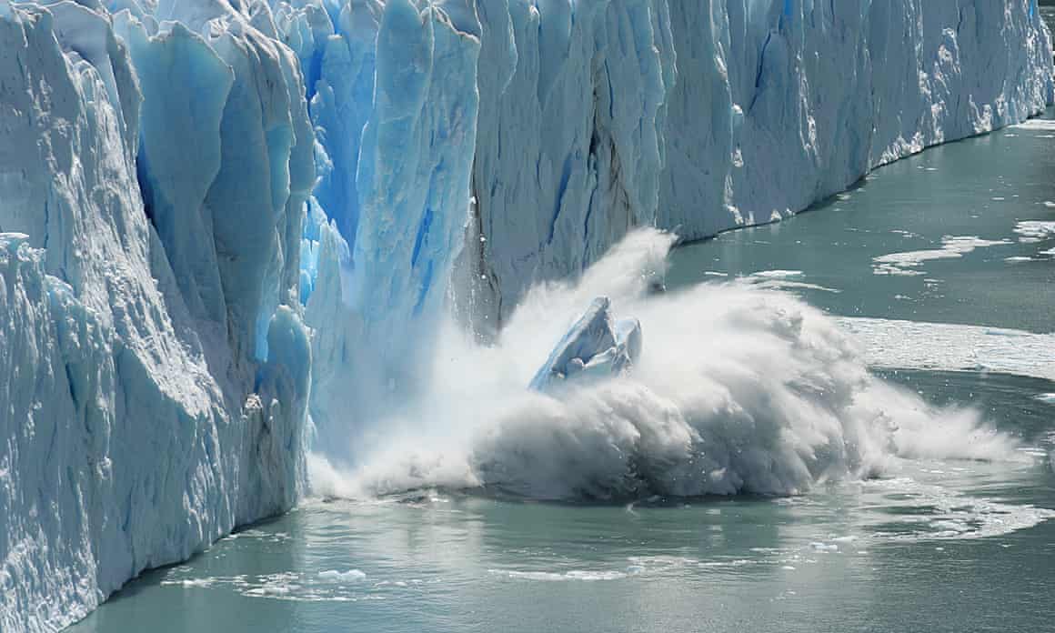 Ice falling into the water as it breaks from an ice shelf