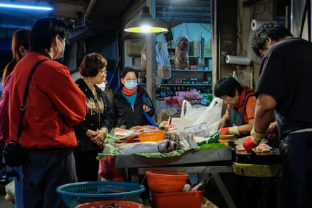 Waiting for her purchases from a fishmonger under a halogen lamp in the Mingde market. Despite fears of contamination from Japan’s recent release of treated nuclear wastewater, her grandson’s appetite is still the most important.