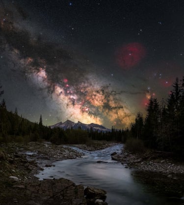 This image is taken in the Białka Gorge in Jurgów, Poland. In the foreground, the river creates a natural leading line, guiding the eye from the earth toward the mountains and into the night sky, visually connecting the terrestrial and the cosmic
