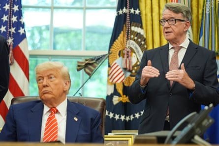 two men in suits, one seated, one standing