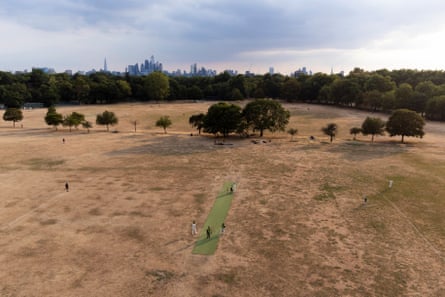 An aerial view of a small green strip of land in an otherwise dry expanse of grass