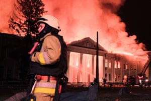 A firefighter stands in front of a blazing building that has been hit by a drone in Kharkiv, Ukraine