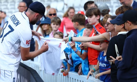 England’s Gus Atkinson signs autographs for fans after the match