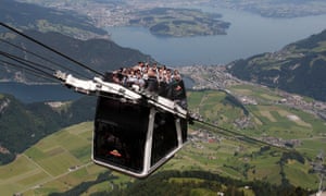 People ride on the world’s first open-air double-decker cable car system, the newly-built “Cabrio”, on the Stanserhorn mountain, near Lucerne