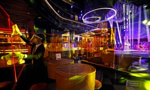 A waiter disinfects plastic screens at a nightclub in Bangkok, Thailand.