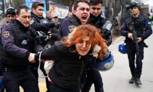 Riot police detain a demonstrator