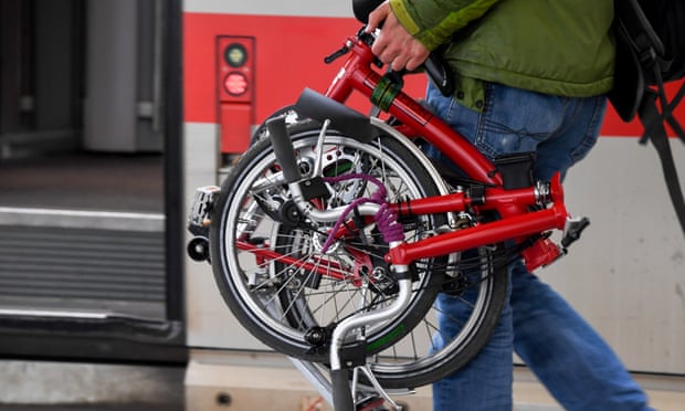 A passenger carries a Brompton on the platform at Munich Central Station.