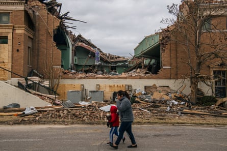 A family walks past a destroyed church in Mayfield, Kentucky.