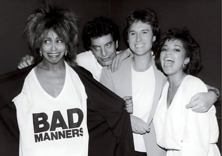 Tina Turner wearing a white T-shirt with the words ‘Bad Manners’ on the front, next to two men in white T-shirts and a woman wearing a white blouse.