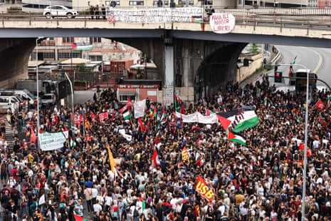 People gather for a demonstration as dockworkers take part in a strike near the port of Genoa.