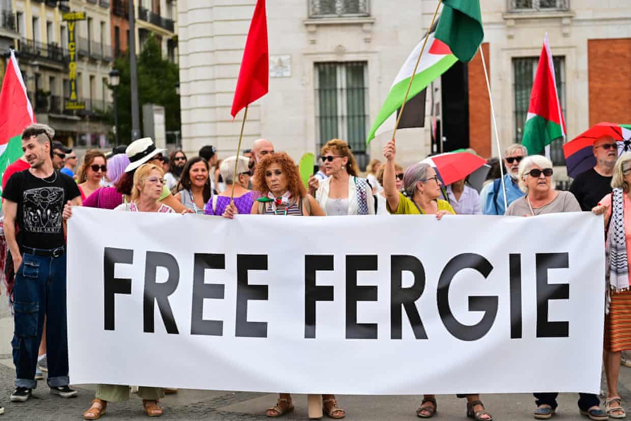 people hold a banner that reads ‘free Fergie’