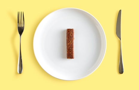 Cereal bar on white plate on yellow background, with knife and fork beside it