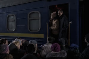People attempt to board a train leaving the station