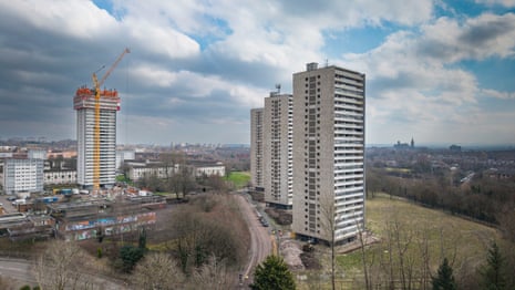 Four high rise blocks with the city and a cloudy sky in the background