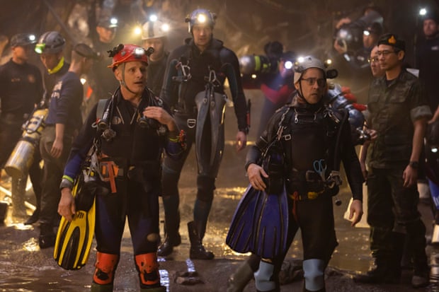 A scene from Thirteen Lives with the rescuers standing in water wearing wetsuits.
