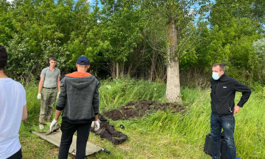 Police exhume a body in pastureland near the village of Zahaltsy in the Bucha district west of Kyiv.
