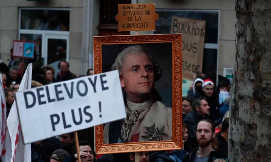 Protesters near Bastille Square in Paris hold a portrait of Emmanuel Macron