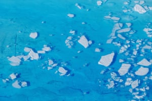 Chunks of ice float inside of meltwater pools on top of the Helheim glacier near Tasiilaq, Greenland, in June 2018