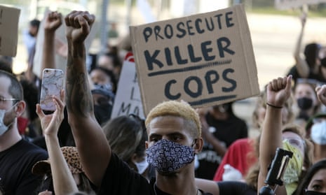 A demonstrator raises his fist during a protest of the death of George Floyd in downtown Los Angeles on 27 May. 