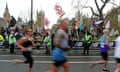 Extinction Rebellion members wave flags while spectating the 2023 London Marathon