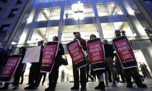 Protesters carry placards outside an Apple store in Boston in support of the firm’s battle with the FBI