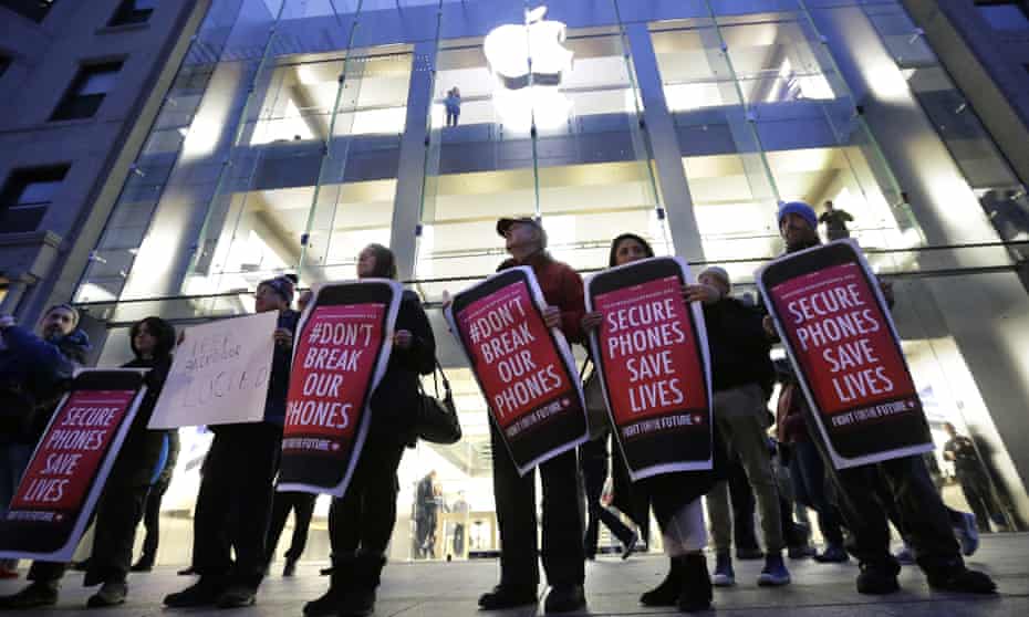 Protesters carry placards outside an Apple store in Boston in support of the firm’s battle with the FBI