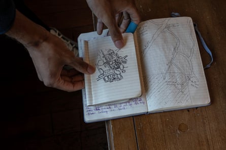 closeup of hands holding a small notebook open with a hand drawn map