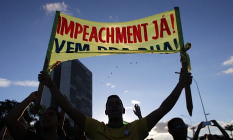 An anti-government protester carries a sign saying ‘Impeachment now!’ outside the presidential palace in Brasilia. 