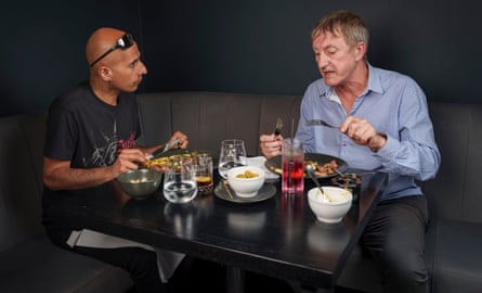 Two men sitting eating at a restaurant table
