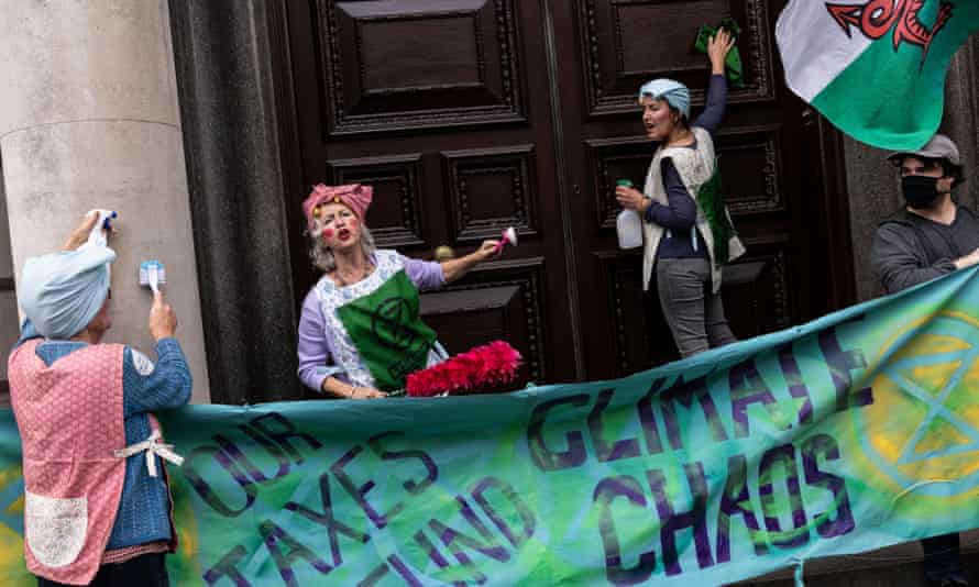 Extinction Rebellion activists scrubbing the doors of HMRC.