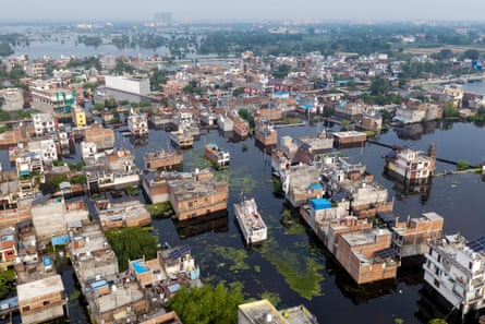 A flooded residential district seen from above. The buildings appear as if they are standing in a lake.