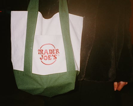 A person carrying a trader joes tote bag