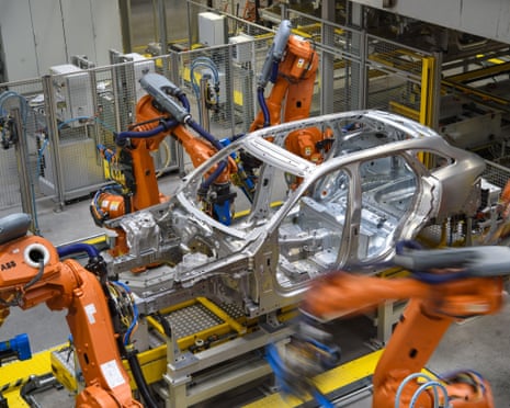 Orange robotic arms rivet together car panels