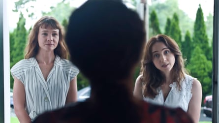 A shot of the back of someone’s head as two women stand in front of them speaking