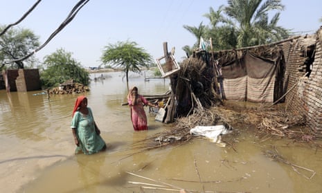 Women wade through a flooded area in the Shikarpur district of Sindh province on Tuesday