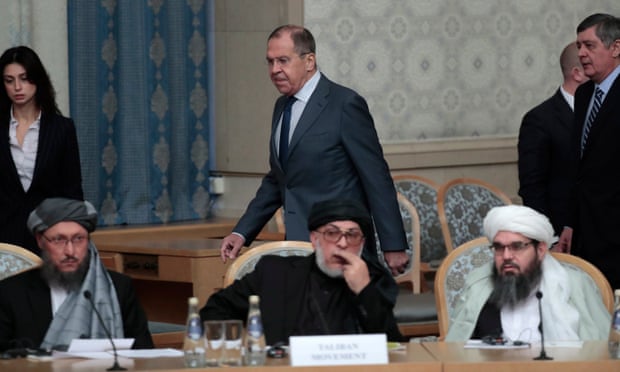 Sergei Lavrov passes members of the Taliban delegation before the start of the talks.