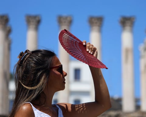 Женщина пользуется вентилятором.