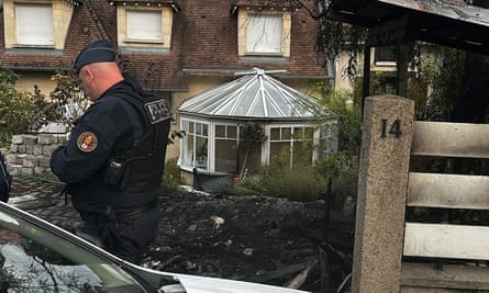Agentes de policía frente a la casa dañada del alcalde de L'Haÿ-les-Roses después de que los alborotadores embistieran un vehículo contra el edificio, hiriendo a su esposa y a uno de sus hijos.