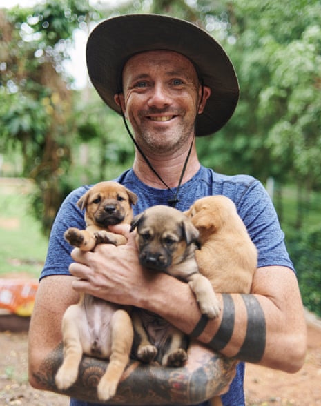Niall Harbison smiling and holding three puppies