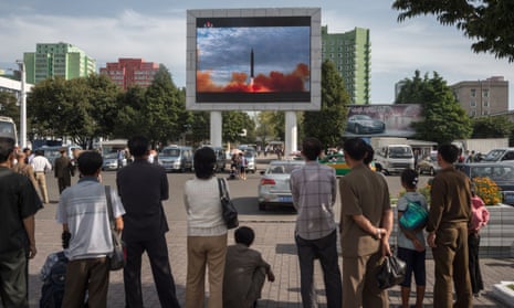 People watch as a screen shows footage of the launch of a Hwasong-12 rocket in Pyongyang on Saturday.
