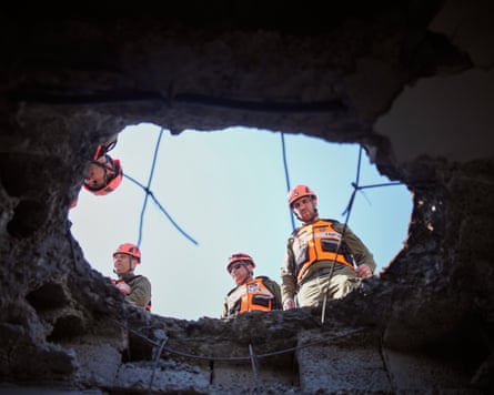 Men peering down large hole